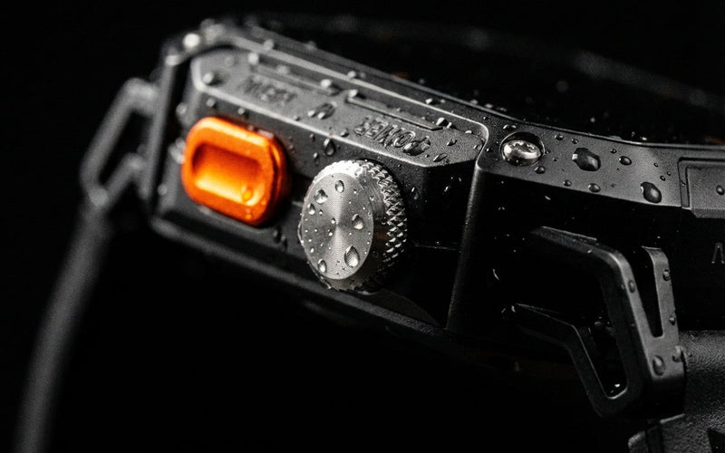 Water droplets on the Njord APEX's zinc alloy case, orange button and crown